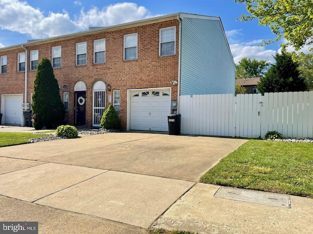 view of front of property with brick siding, an attached garage, a gate, fence, and driveway