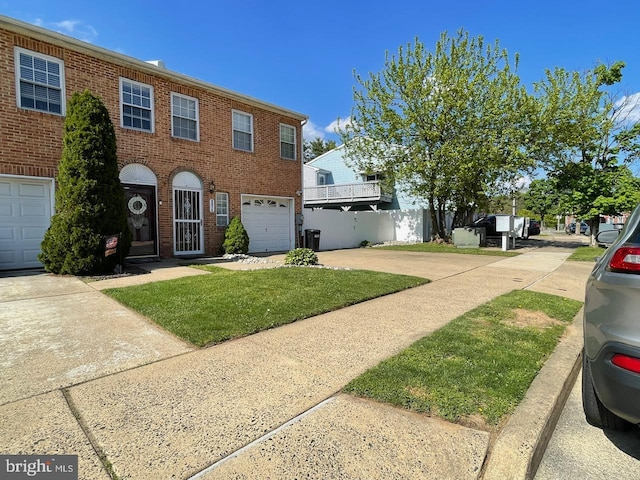 view of front facade featuring an attached garage, a front lawn, concrete driveway, and brick siding