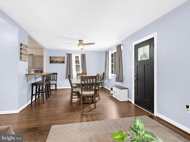 dining space with ceiling fan and dark wood-type flooring