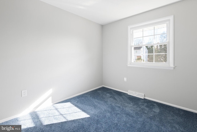 unfurnished room featuring dark carpet