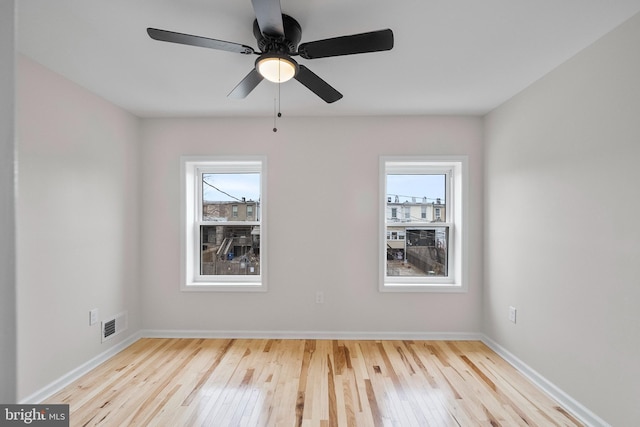 spare room with ceiling fan and light wood-type flooring