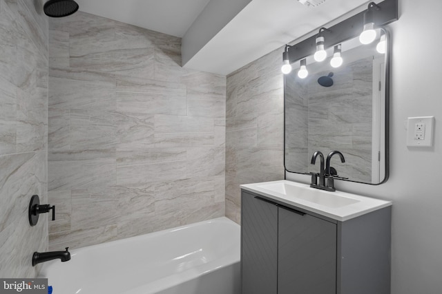 bathroom featuring tiled shower / bath combo and vanity