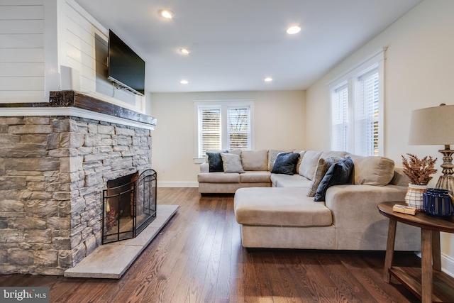 living room with a fireplace and dark wood-type flooring