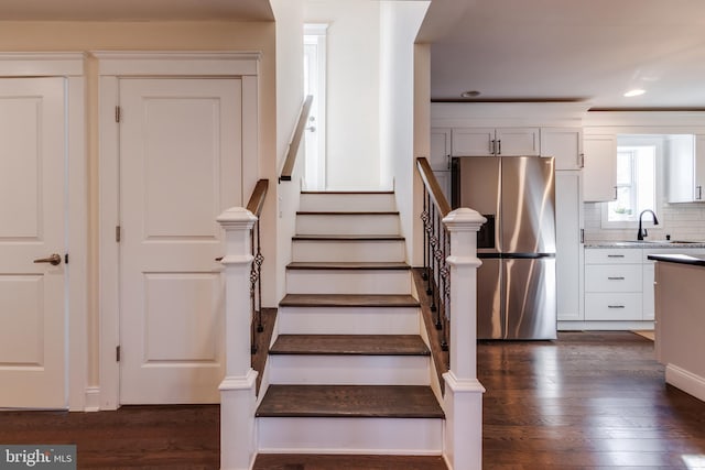 staircase with sink and hardwood / wood-style floors