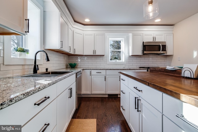 kitchen with white cabinetry, sink, stainless steel appliances, wood counters, and dark hardwood / wood-style floors