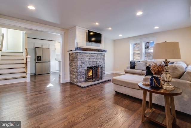 living room with a fireplace and dark wood-type flooring