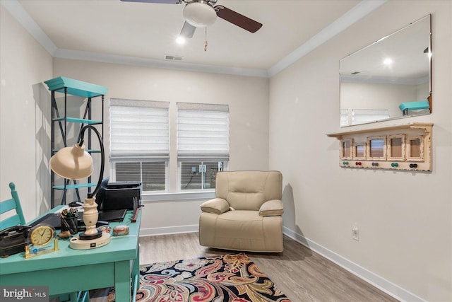 living area featuring hardwood / wood-style flooring, ceiling fan, and ornamental molding