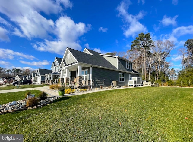 view of home's exterior with a porch, central AC unit, and a lawn