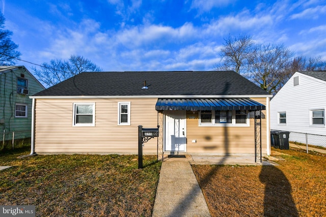 bungalow featuring cooling unit and a front lawn