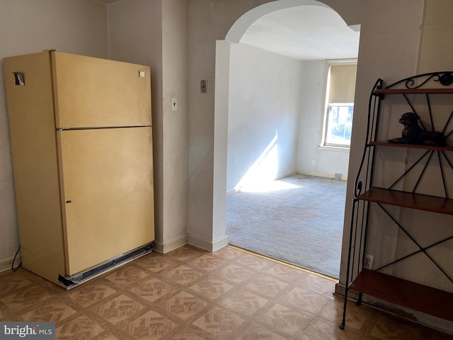 kitchen with light carpet and white fridge