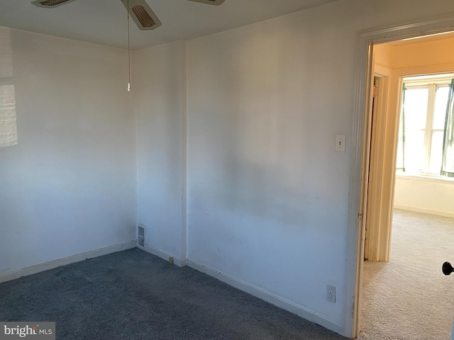 carpeted spare room featuring ceiling fan