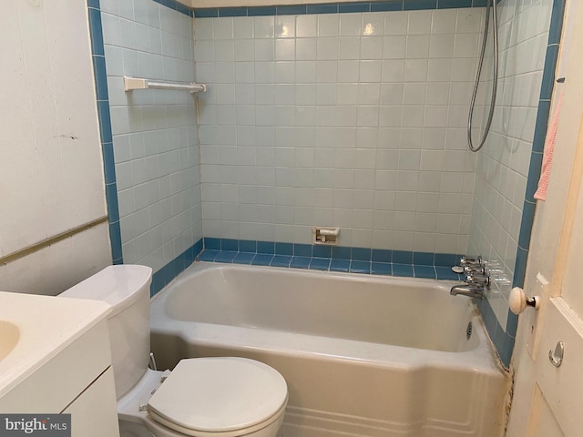 full bathroom with vanity, tiled shower / bath combo, and toilet