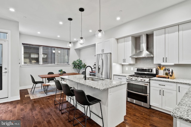 kitchen featuring dark hardwood / wood-style floors, white cabinetry, wall chimney range hood, and stainless steel appliances