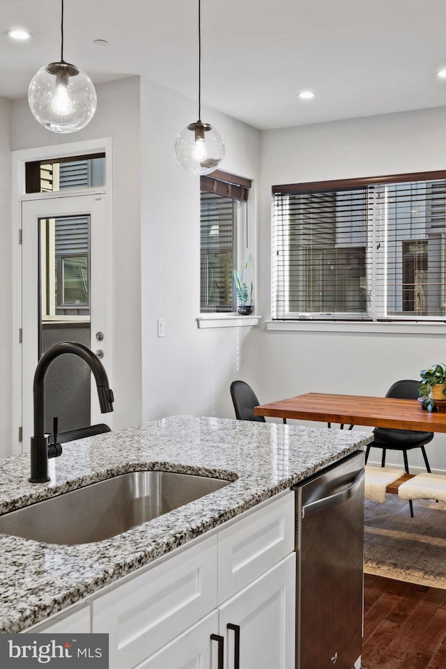 kitchen with pendant lighting, dark hardwood / wood-style floors, white cabinetry, and sink