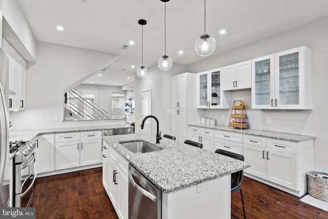 kitchen with a kitchen island with sink, white cabinetry, sink, and stainless steel appliances