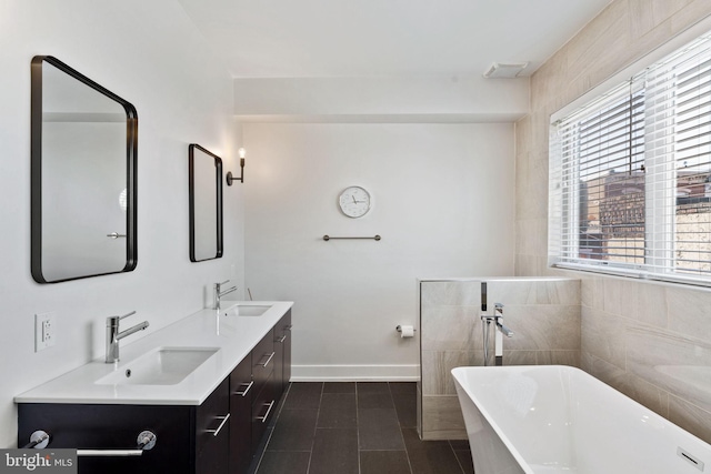 bathroom with tile patterned flooring, vanity, a bath, and tile walls