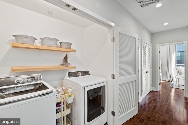 clothes washing area with separate washer and dryer and dark hardwood / wood-style flooring