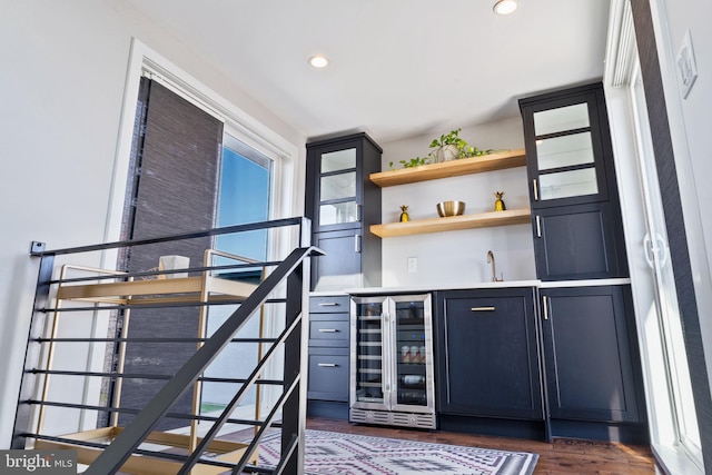 bar featuring wine cooler, sink, and dark hardwood / wood-style floors