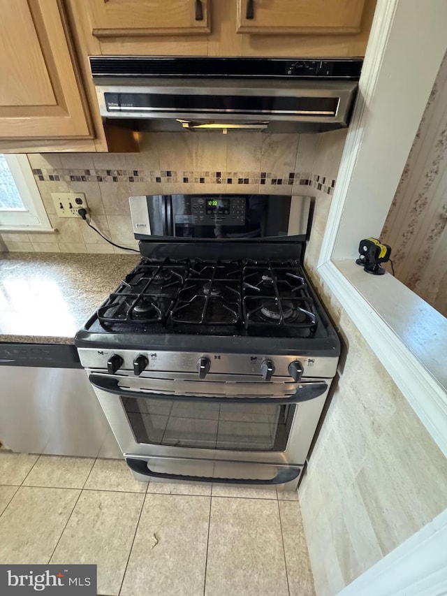 interior space with tasteful backsplash, extractor fan, and stainless steel range with gas stovetop