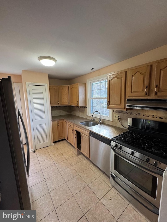 kitchen featuring exhaust hood, sink, light tile patterned floors, appliances with stainless steel finishes, and tasteful backsplash