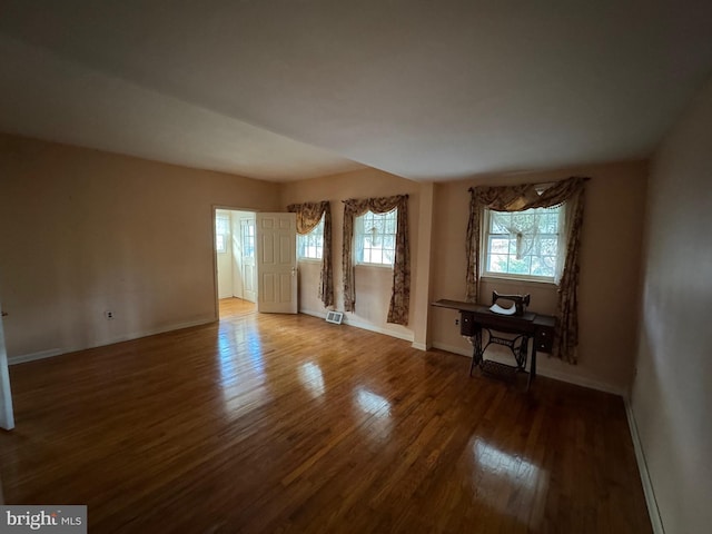 empty room with dark hardwood / wood-style flooring