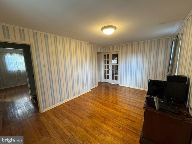 unfurnished living room with wood-type flooring and french doors