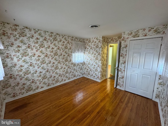 unfurnished bedroom featuring hardwood / wood-style floors and a closet