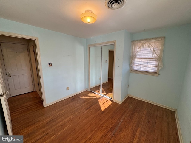 unfurnished bedroom featuring wood-type flooring and a closet