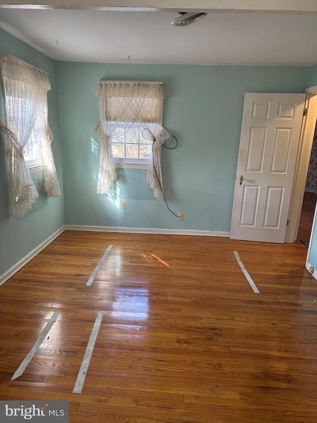 unfurnished room with wood-type flooring