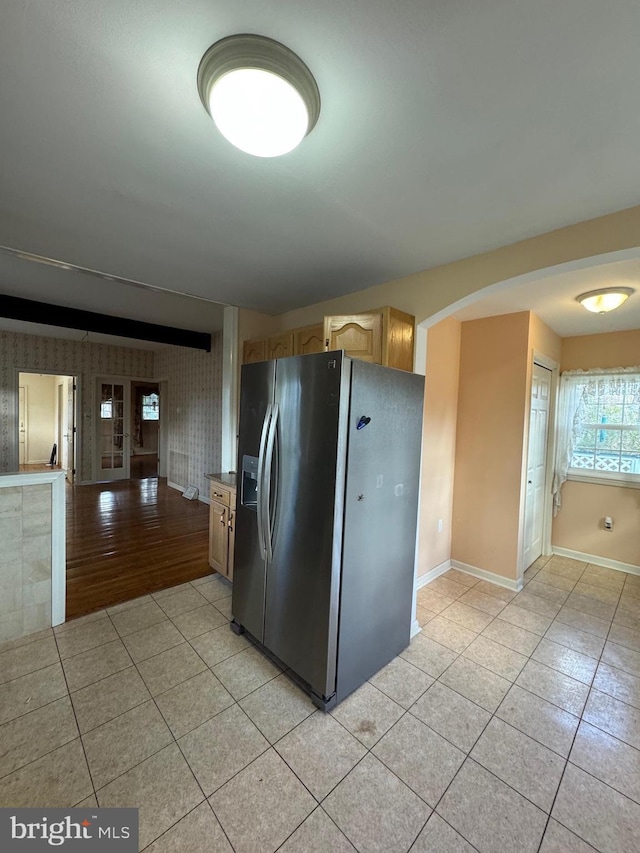 kitchen featuring light brown cabinets, french doors, stainless steel refrigerator with ice dispenser, and light hardwood / wood-style flooring