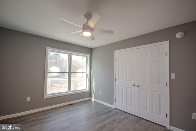 unfurnished bedroom with a closet, ceiling fan, and light hardwood / wood-style flooring