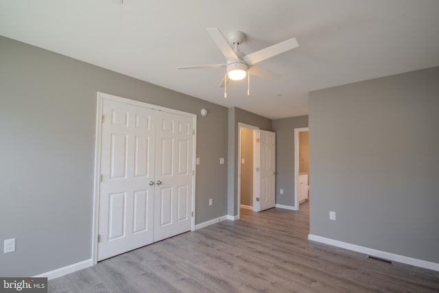 unfurnished bedroom with ceiling fan, light wood-type flooring, and a closet