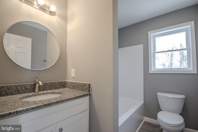 bathroom featuring hardwood / wood-style floors, vanity, toilet, and a bathtub