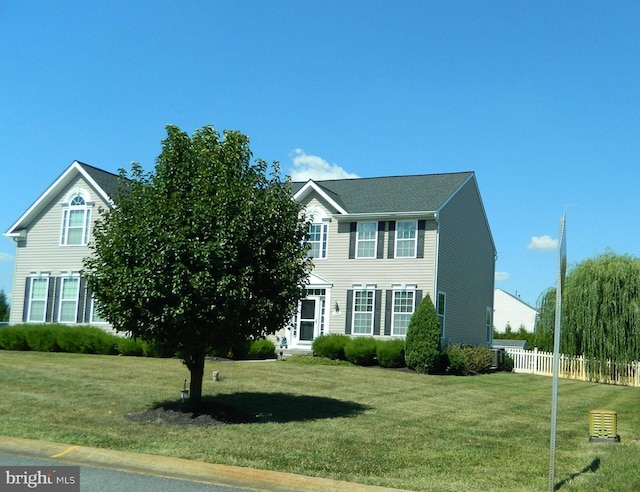 colonial-style house featuring a front yard