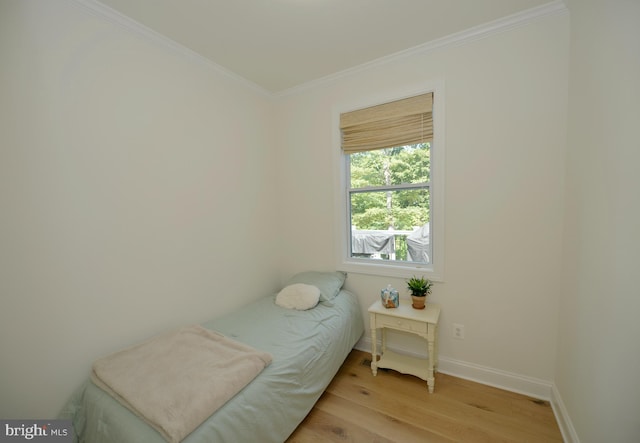 bedroom featuring crown molding and light hardwood / wood-style floors