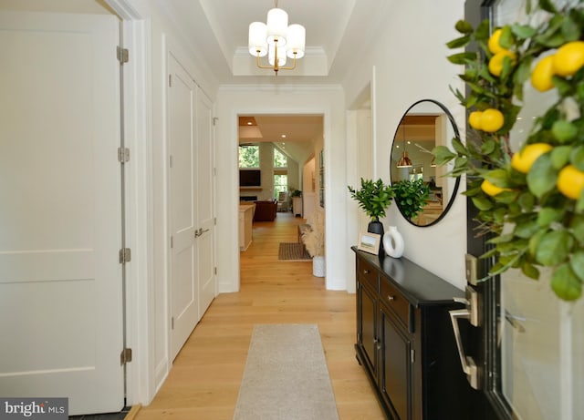 corridor with a notable chandelier and light hardwood / wood-style floors