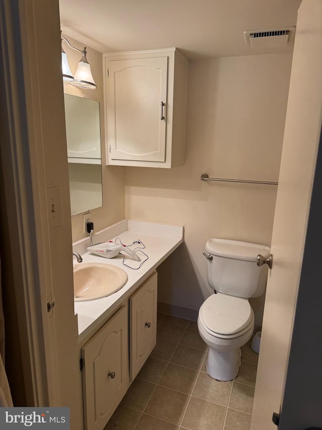 bathroom featuring toilet, vanity, and tile patterned floors