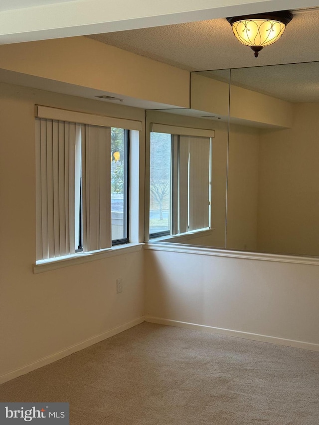 empty room with a textured ceiling and carpet floors