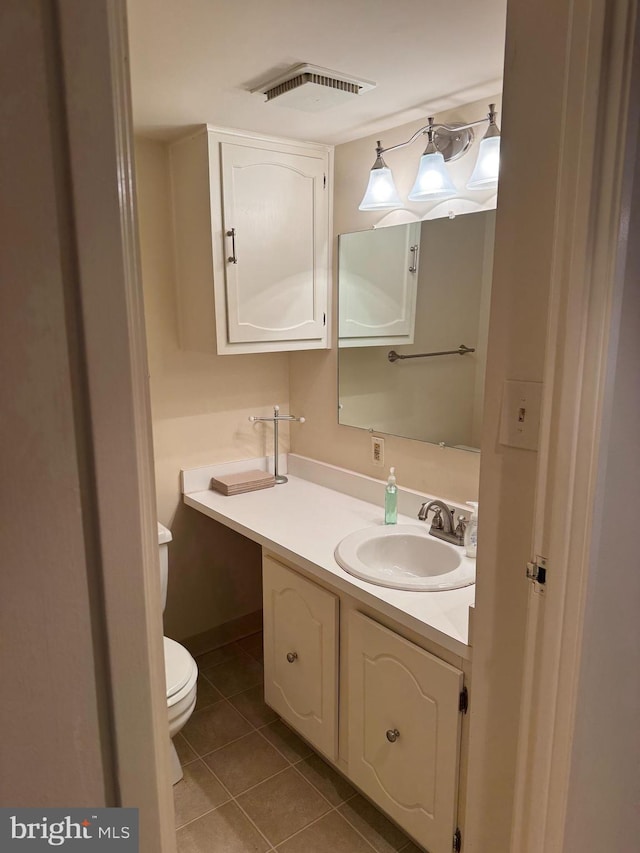 bathroom with tile patterned flooring, vanity, and toilet