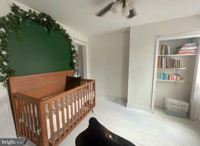 bedroom with ceiling fan and a crib