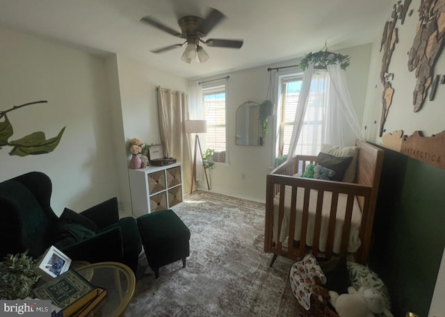 bedroom with ceiling fan and a nursery area