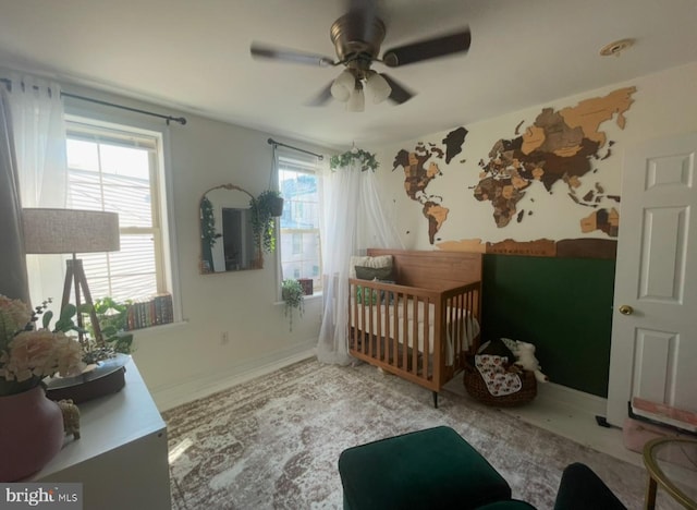 bedroom with ceiling fan and a crib