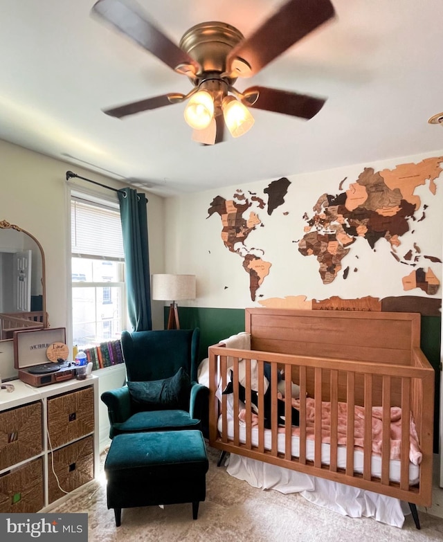 bedroom with ceiling fan and a crib