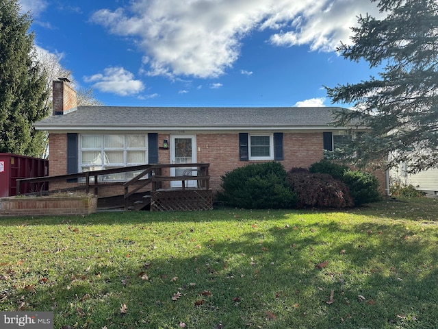 view of front of property with a wooden deck and a front yard