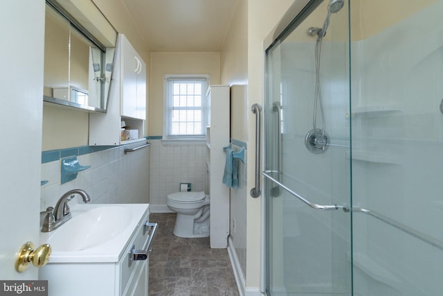 bathroom with an enclosed shower, vanity, toilet, and tile walls