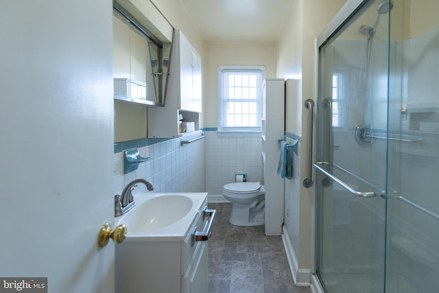 bathroom featuring vanity, an enclosed shower, tile walls, and toilet