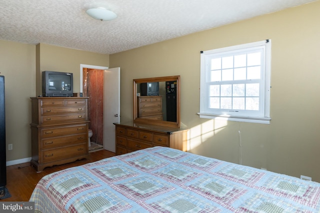 bedroom with wood-type flooring and a textured ceiling