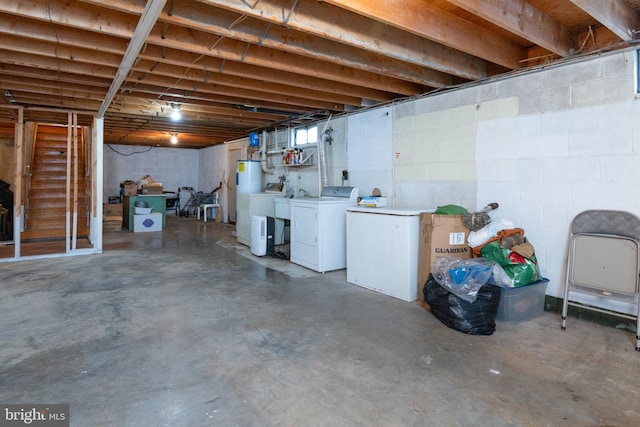 basement featuring electric water heater and washer and clothes dryer