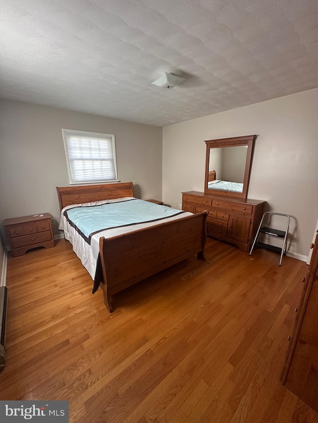 bedroom featuring a textured ceiling and light wood-type flooring