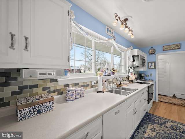 kitchen featuring electric range, decorative backsplash, dishwasher, white cabinetry, and a sink